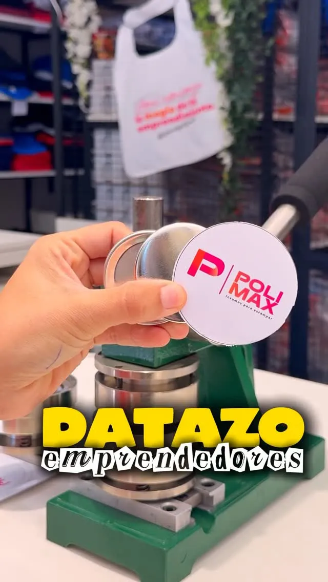 Máquina prensa de pines y chapas color verde sosteniendo un botón con el logo de Polimax